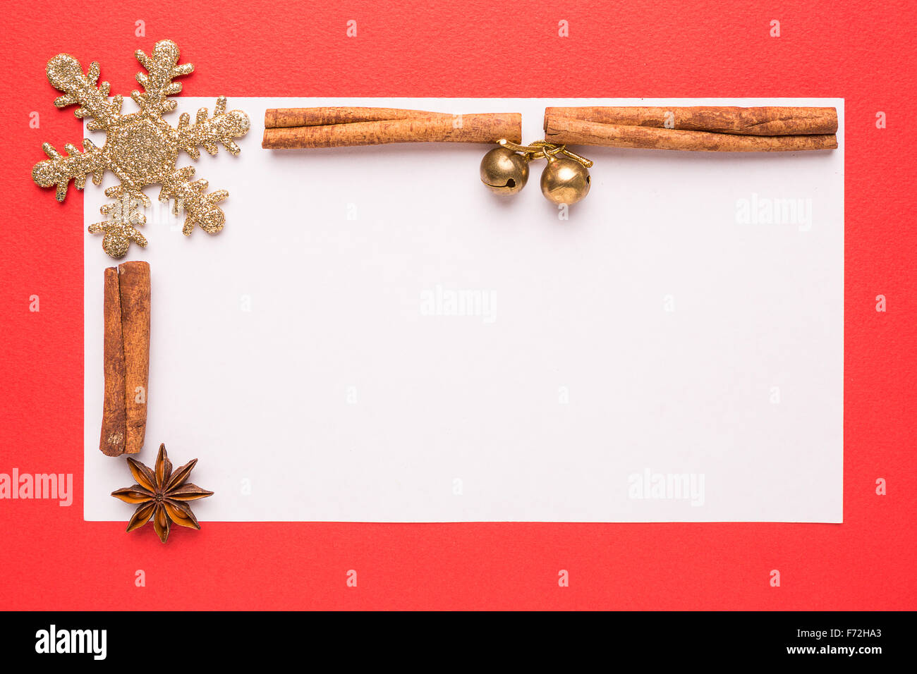Tarjeta de Navidad en blanco con anís estrella y canela sobre fondo rojo. Foto de stock