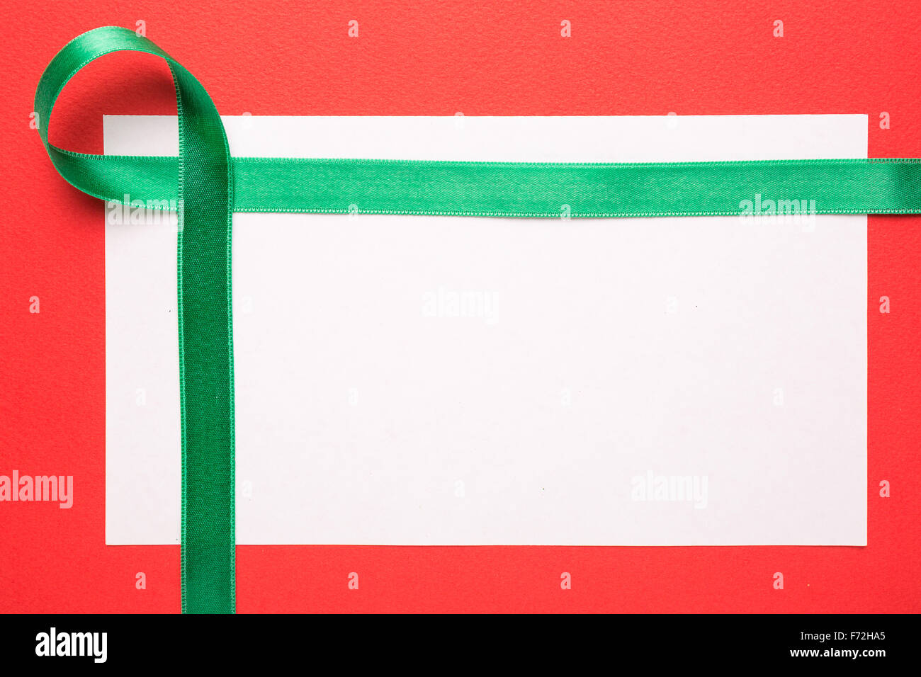 Tarjeta de Navidad o Invitaciones en blanco con cinta verde sobre fondo rojo. Foto de stock