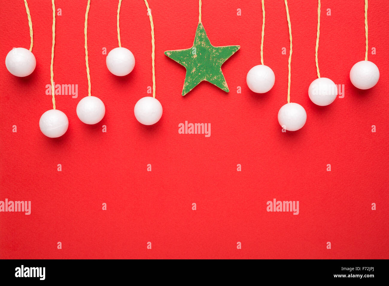 Tarjeta de navidad con decoración colgantes sobre fondo rojo. Foto de stock
