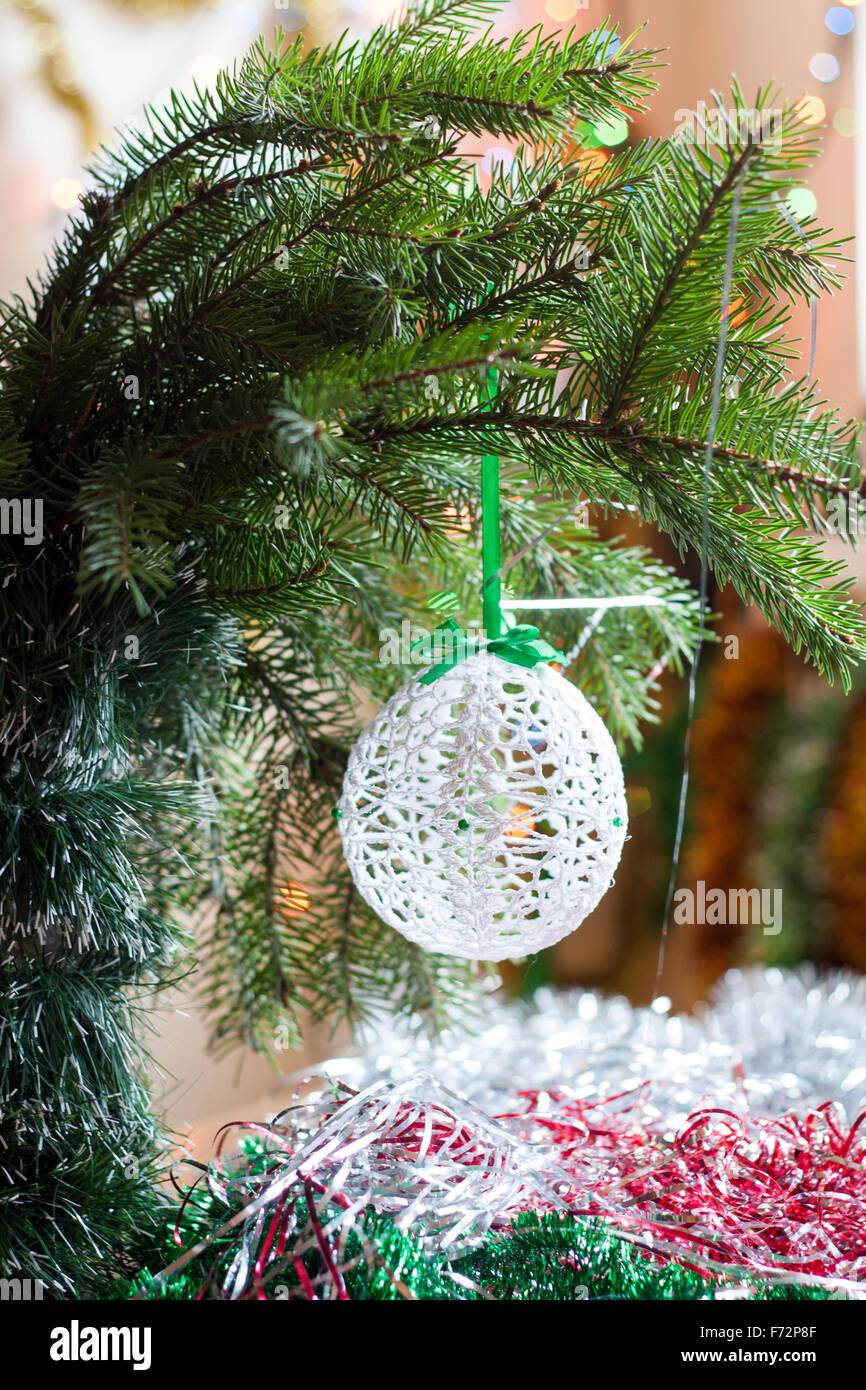 Navidad tejida crochet bola en árbol en coloridos bokeh de fondo entre la  decoración de Navidad y Año Nuevo Fotografía de stock - Alamy