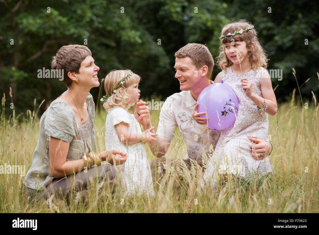 Familia con dos niños jugando en un prado. Foto de stock