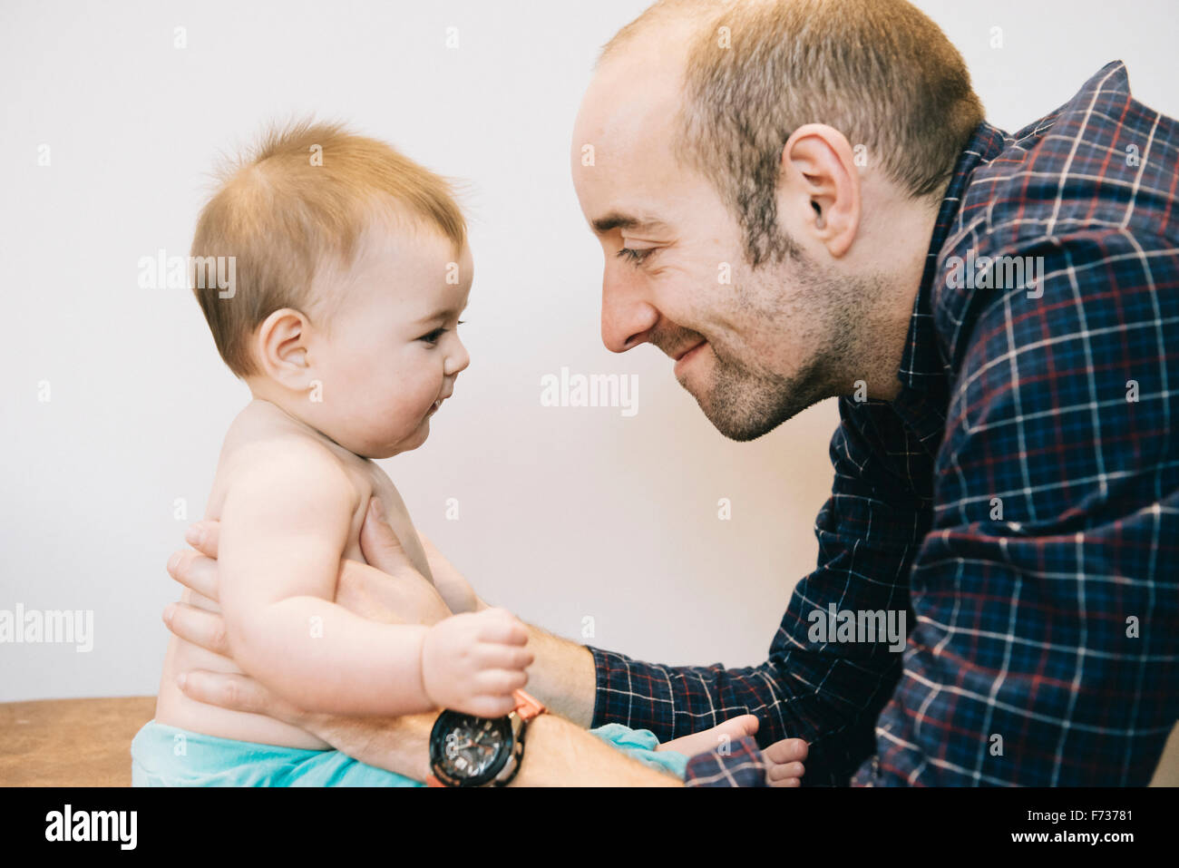 Una joven niña y su padre jugando cara a cara. Foto de stock