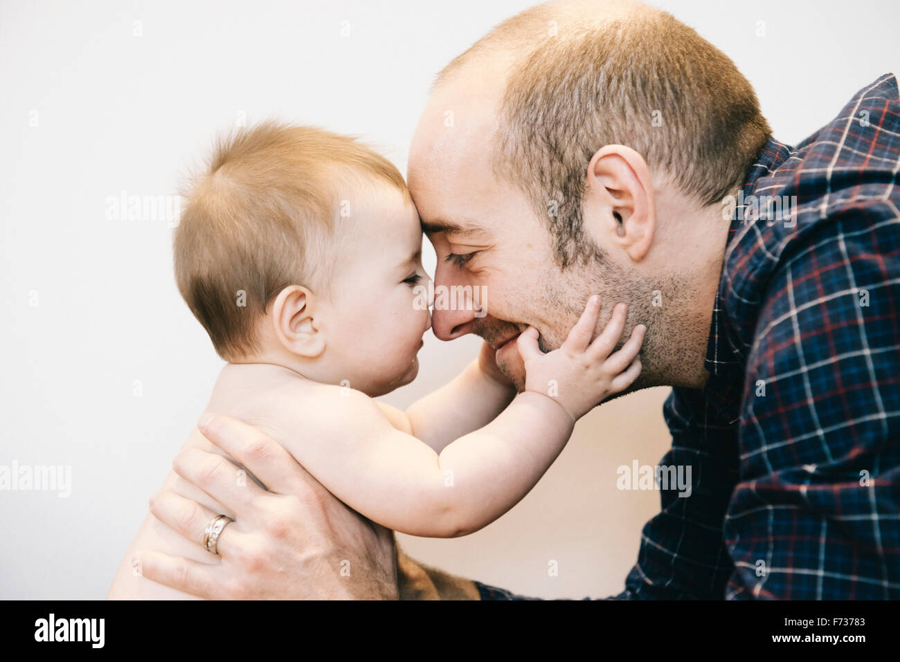 Una joven niña y su padre jugando cara a cara. Foto de stock