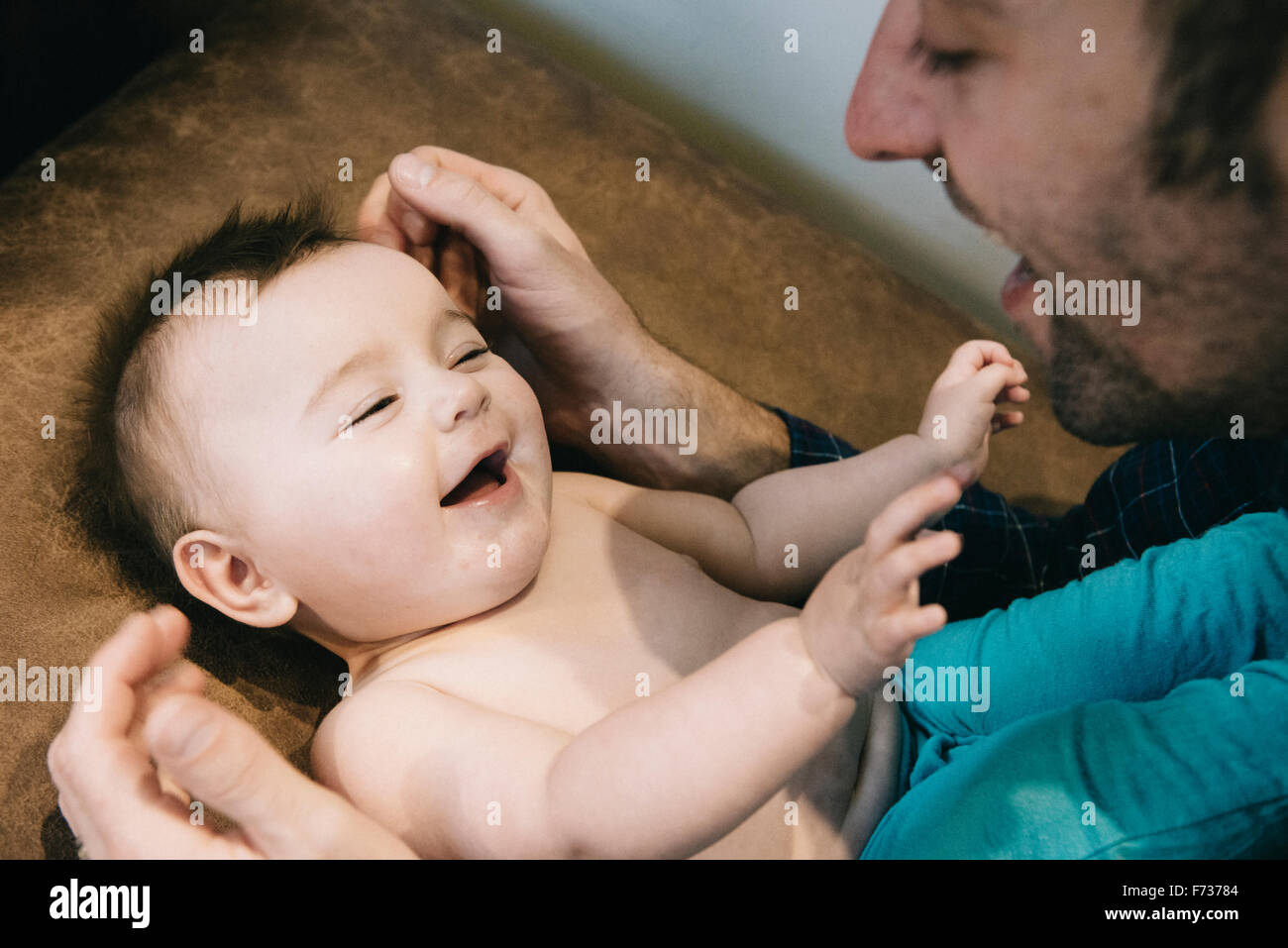Un hombre y un bebé pequeño mirando y riendo. Foto de stock