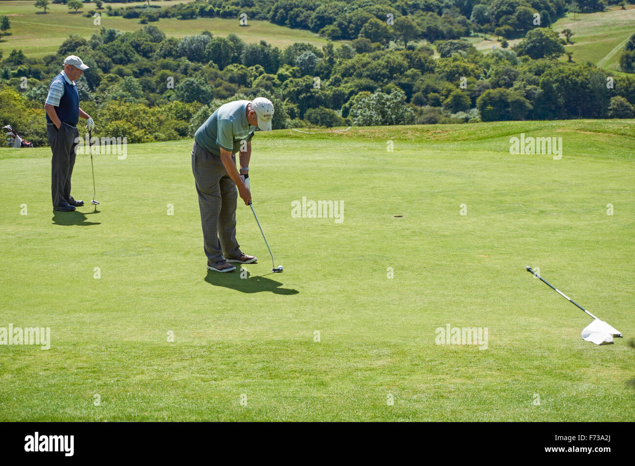 Los golfistas mayores jugando al Golf Club Pyecombe, West Sussex, Inglaterra, Reino Unido Foto de stock