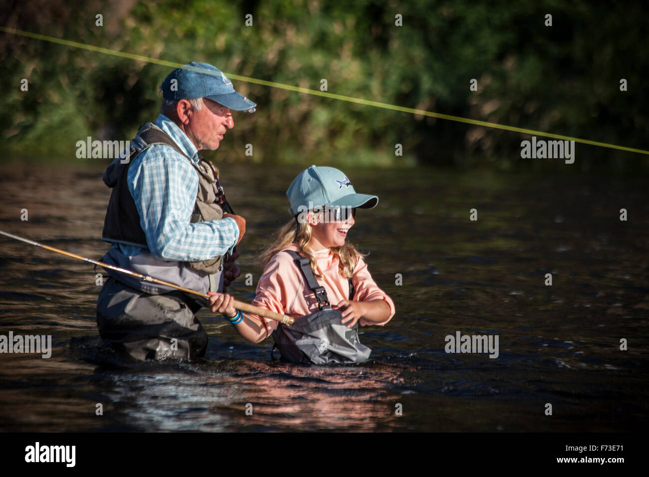 Un hombre senior enseñanza tenkara fly fishing en Fall River, ID. Foto de stock