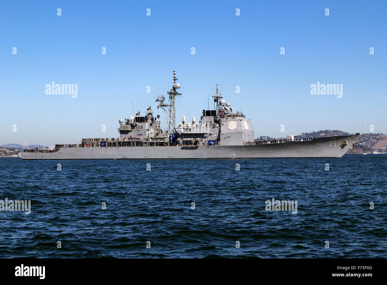 Con la tripulación recubren los carriles la clase Arleigh Burke de misiles guiados destructor USS Ross (DDG-71) entra en la Bahía de San Francisco. Foto de stock