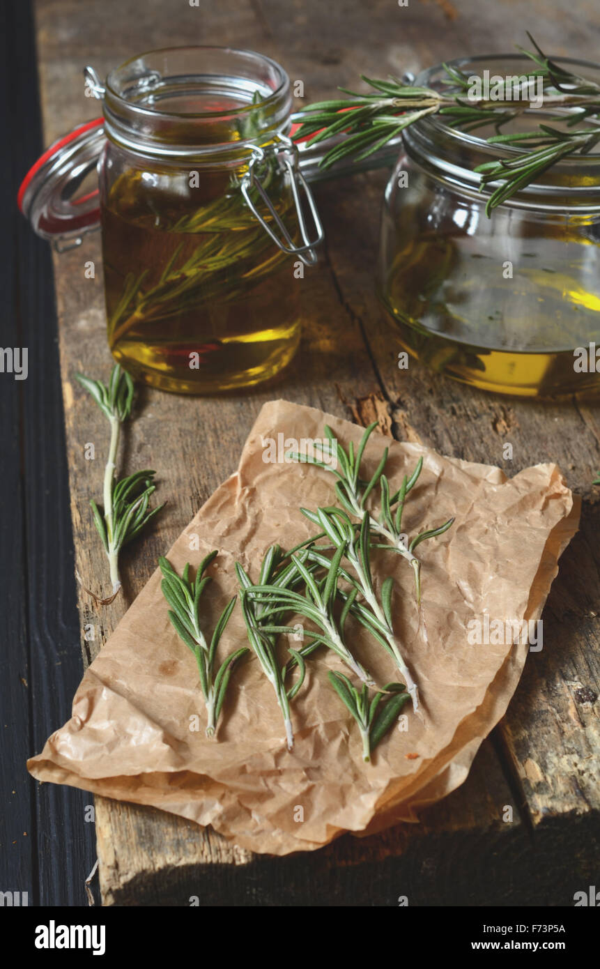 Hacer fragante romero aceite con aceite de oliva y hierbas frescas Foto de stock