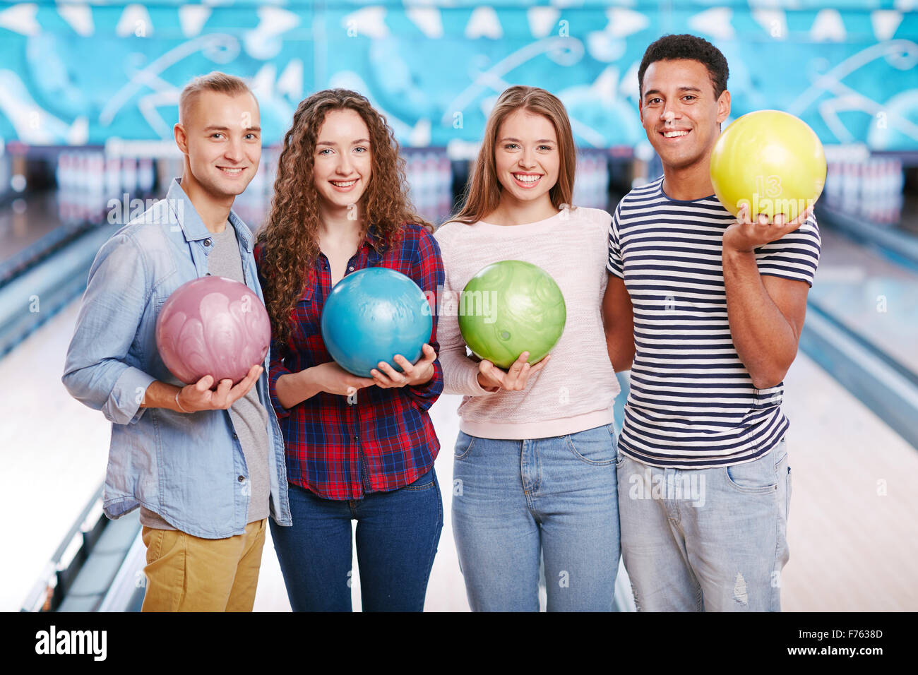 Un grupo de cuatro amigos sujetando bolas y sonriente Fotografía de stock -  Alamy