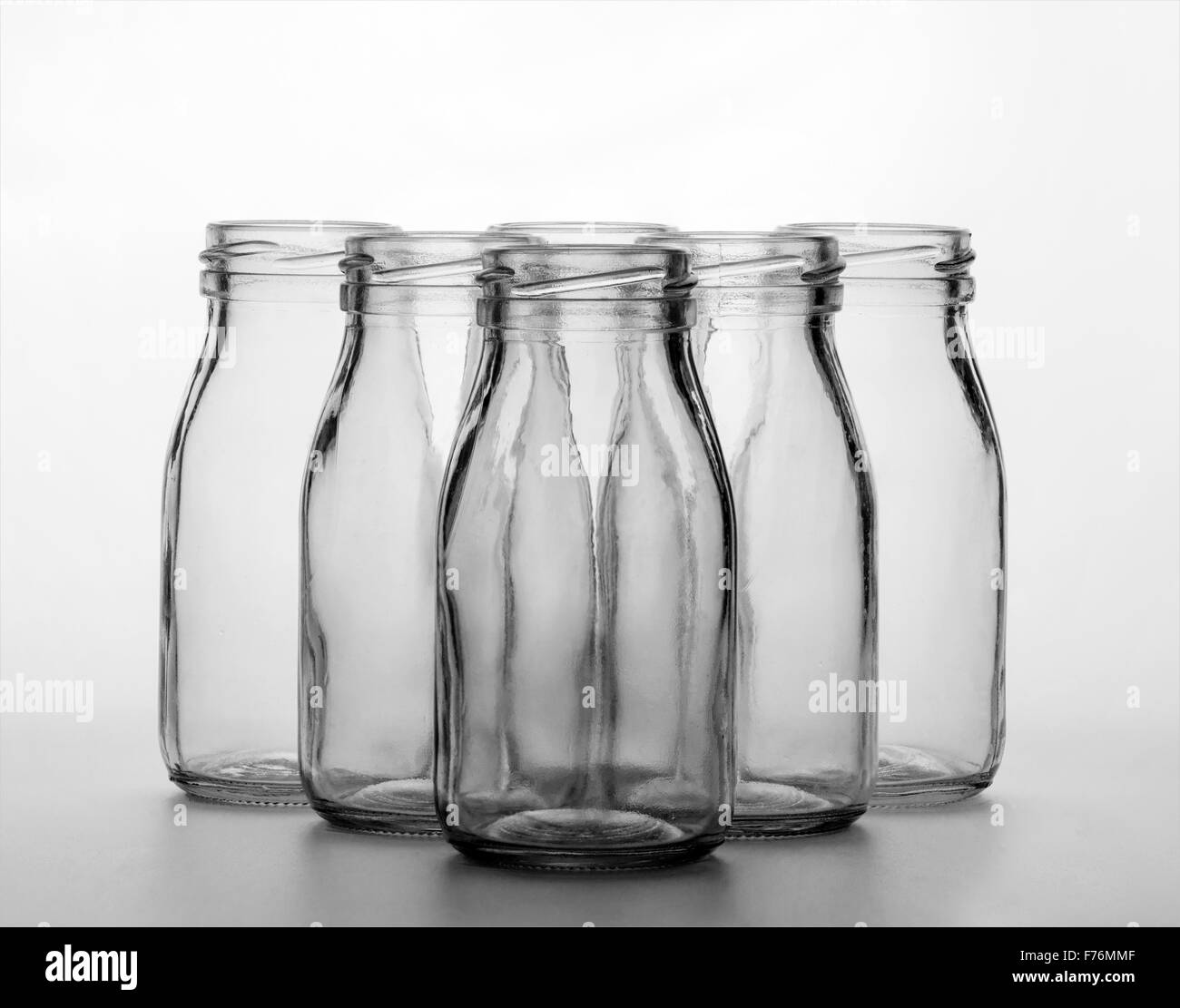 Botellas de leche de vidrio tradicionales en formación fotografiado en mono Foto de stock