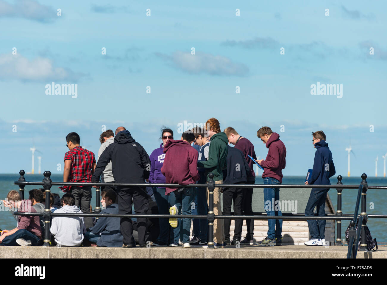 Grupo de estudiantes en viaje de estudio foreshore, Herne Bay, Kent, Inglaterra, Reino Unido Foto de stock