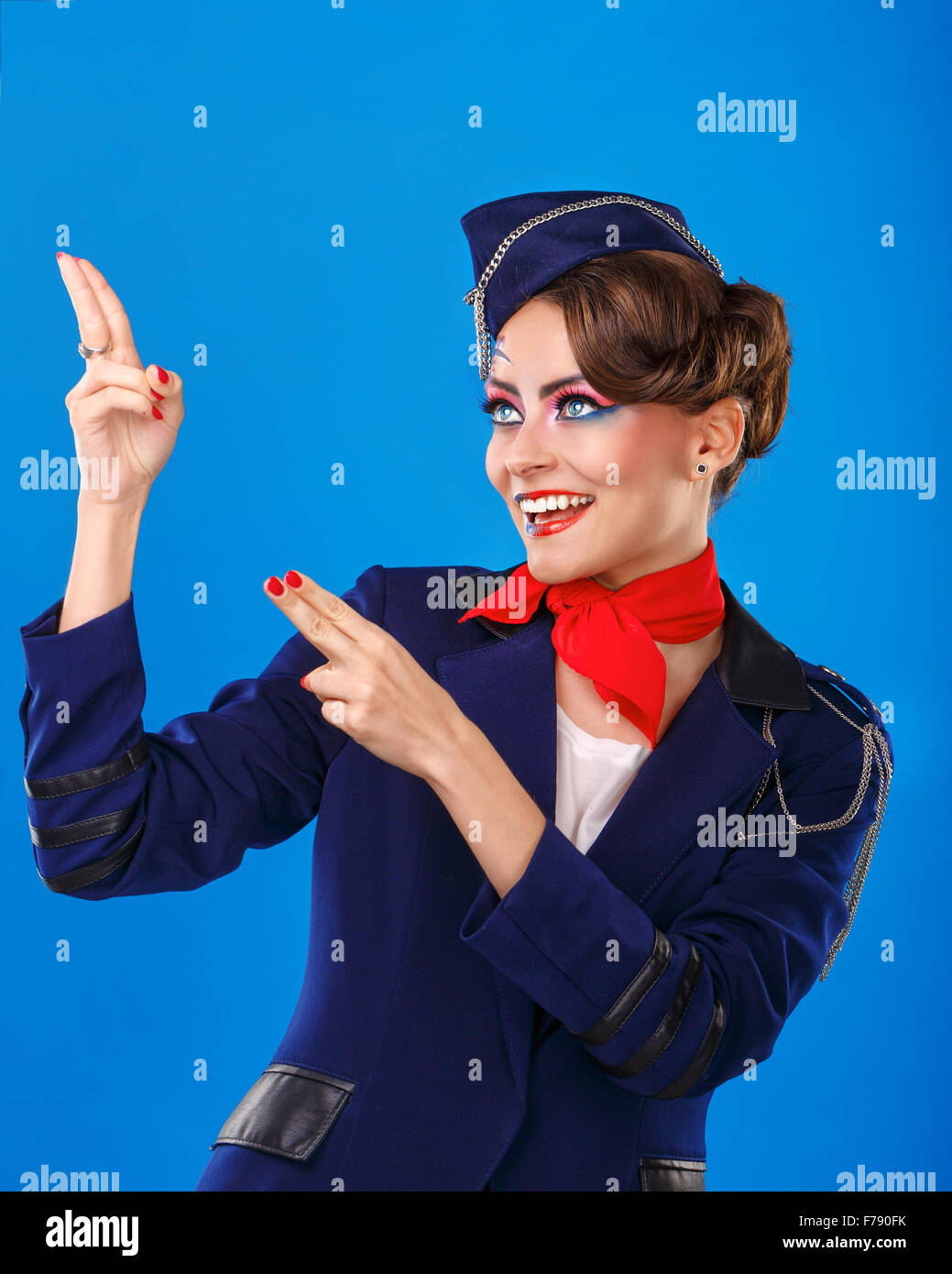 Azafata con cara de arte muestra brazos arriba. Atractiva chica joven en un traje  azul de asistentes de vuelo. Los servicios aéreos Fotografía de stock -  Alamy