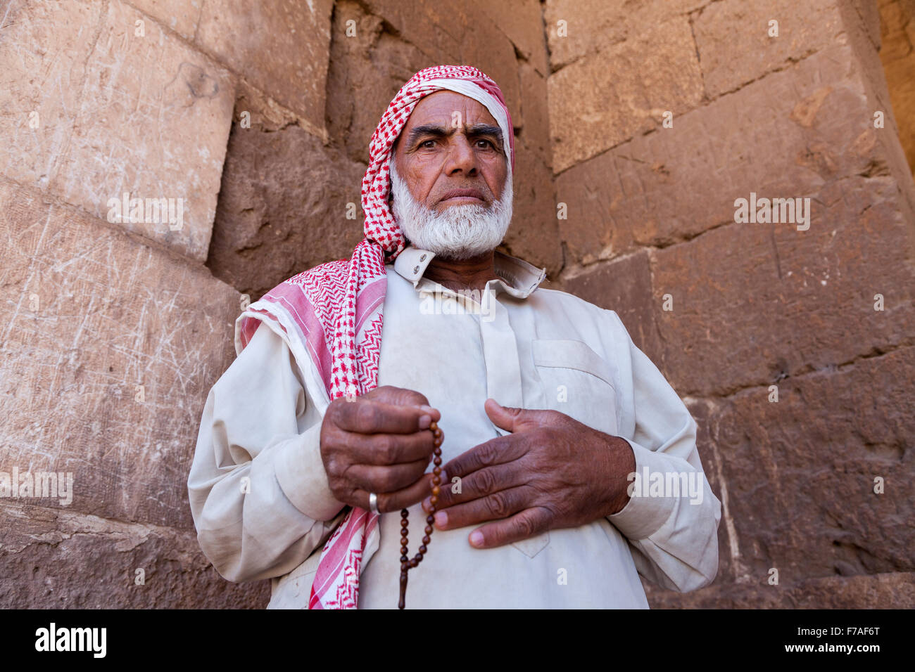 Hombre viejo con su aderezo tradicional se sitúa delante de las areniscas de un antiguo edificio en la llanura de Harran, Sanliurfa, Turquía Foto de stock