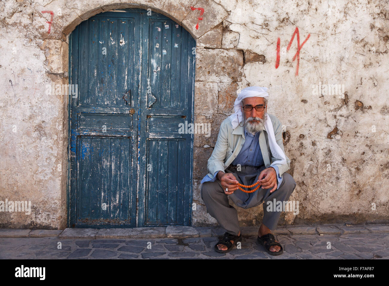 Hombre viejo con su aderezo tradicional se sitúa delante de las areniscas de un antiguo edificio en la llanura de Harran, Sanliurfa, Turquía Foto de stock