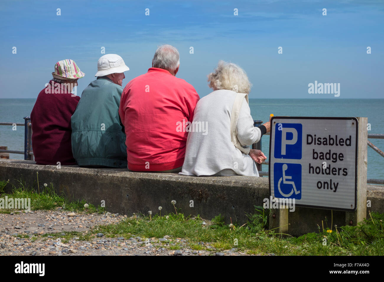 El grupo de pensionistas, con vista al mar en el sol en St Margarets Bay cerca de Dover Kent Foto de stock