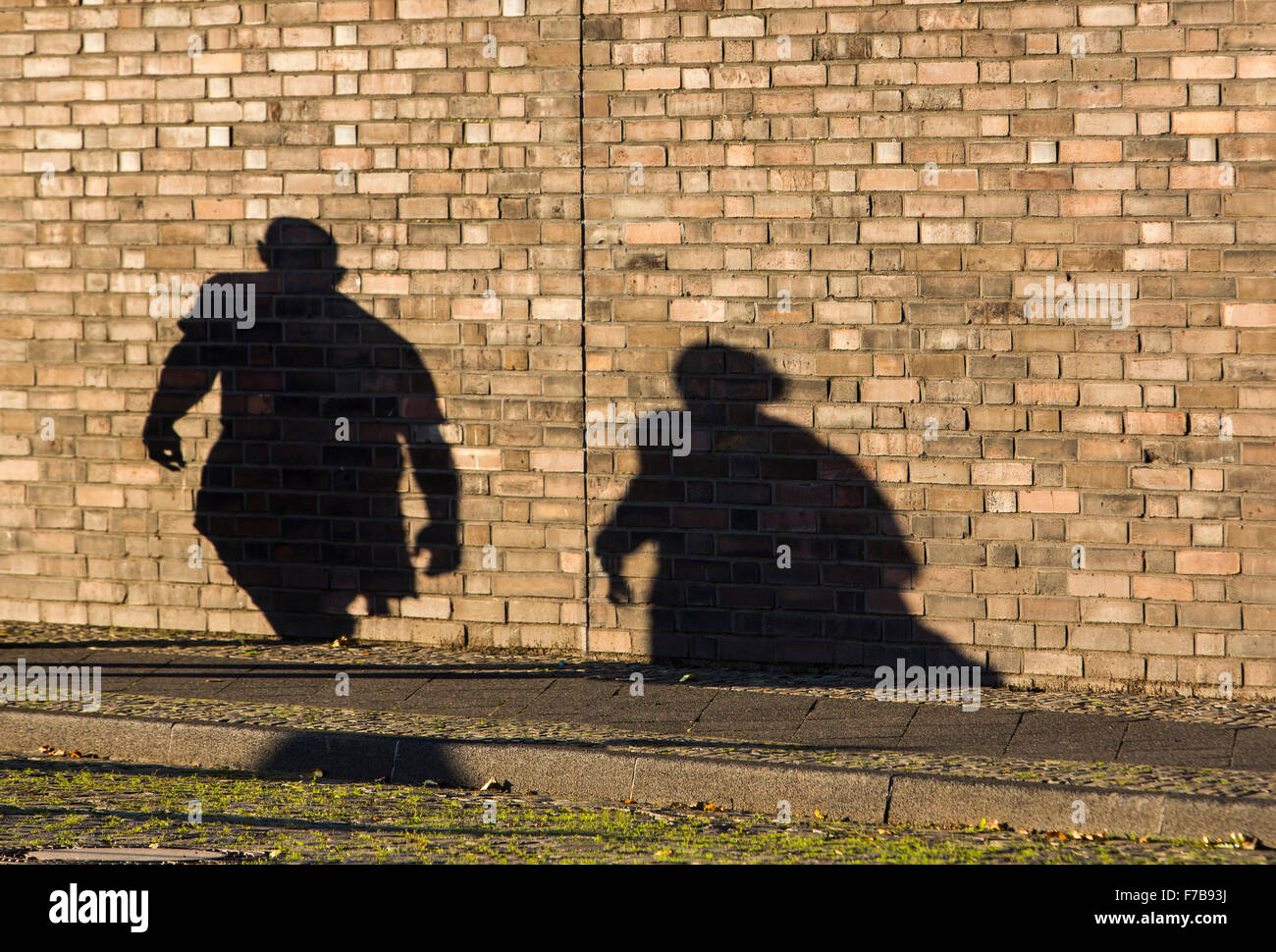 Sombra de 2 personas, hombre, mujer, sobre una pared de ladrillos Foto de stock