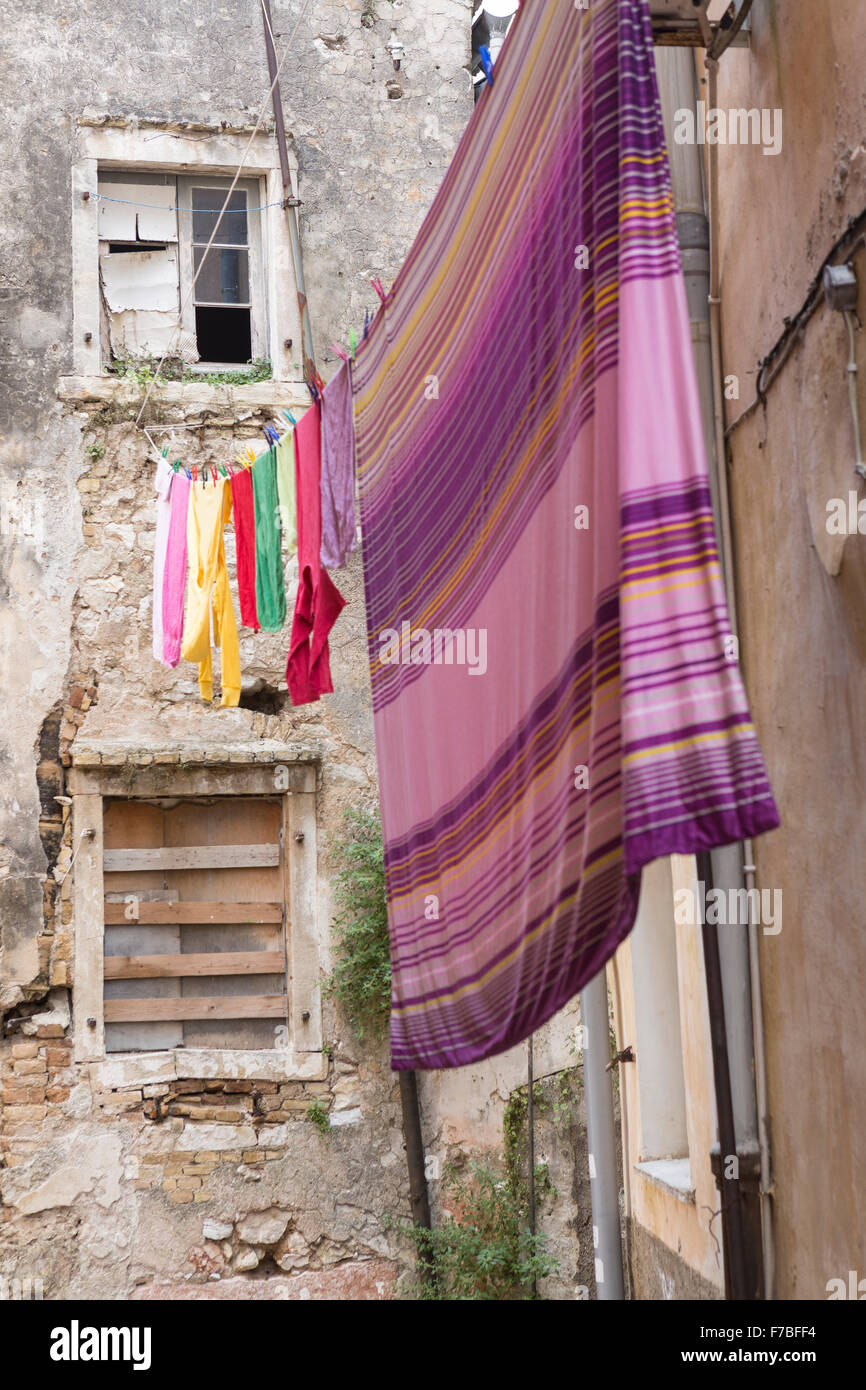 La calle de atrás en Corfú con coloridas colgando afuera para lavado en seco en la calle. Corfu Foto de stock