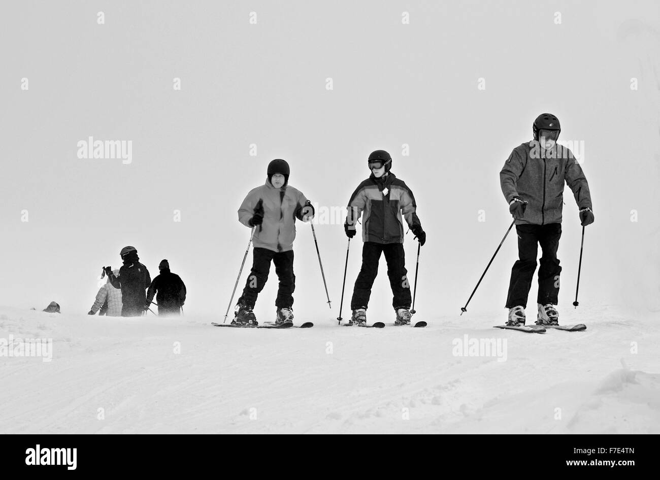 Los esquiadores vistiendo ropa de invierno completo en montañas Cairngorm en frío y viento condiciones meteorológicas adversas con mala visibilidad. Foto de stock