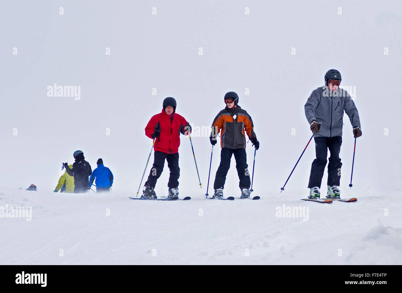 Los esquiadores vistiendo ropa de invierno completo en montañas Cairngorm en frío y viento condiciones meteorológicas adversas con mala visibilidad. Foto de stock