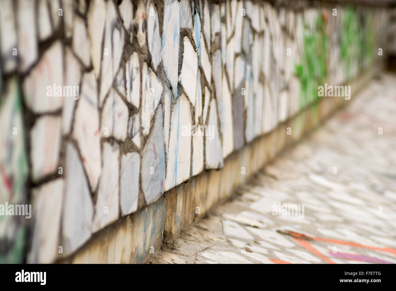 Viejo muro de ladrillos cerámicos con pintura en aerosol de vandalismo que no se puede leer Foto de stock