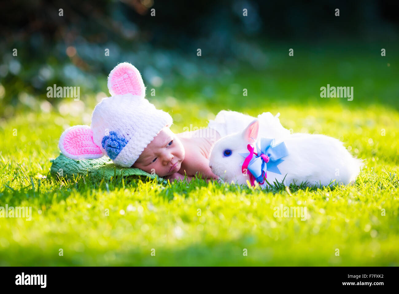 Lindo bebé recién nacido niño en traje de conejito llevar sombrero con  orejas y pañales blancos y un conejo real en verde jardín durante la Pascua  Fotografía de stock - Alamy