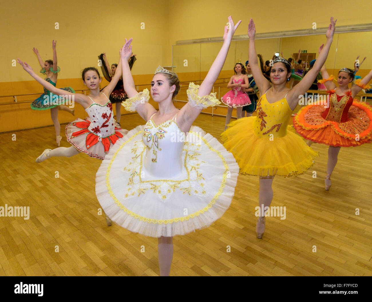 Formación de jóvenes bailarinas en la barra de ballet grupo de bailarines  de ballet posando cerca de la barra en el estudio de ballet