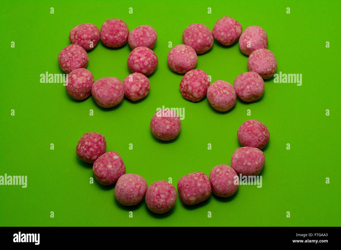 Cara sonriente con rosa bombón dulces Foto de stock