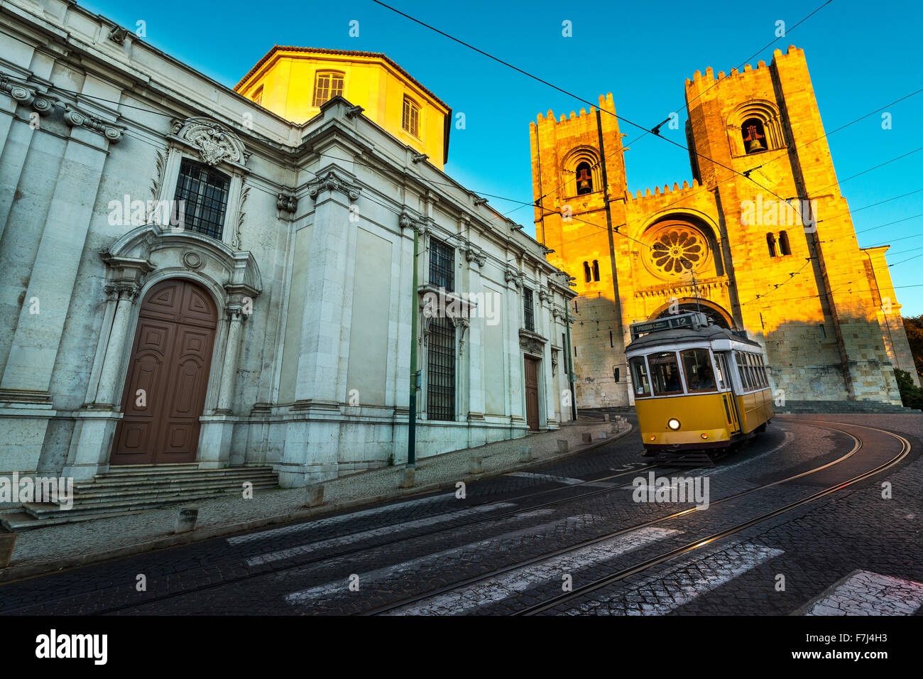 Tranvía en frente de la Catedral de Lisboa al atardecer Foto de stock