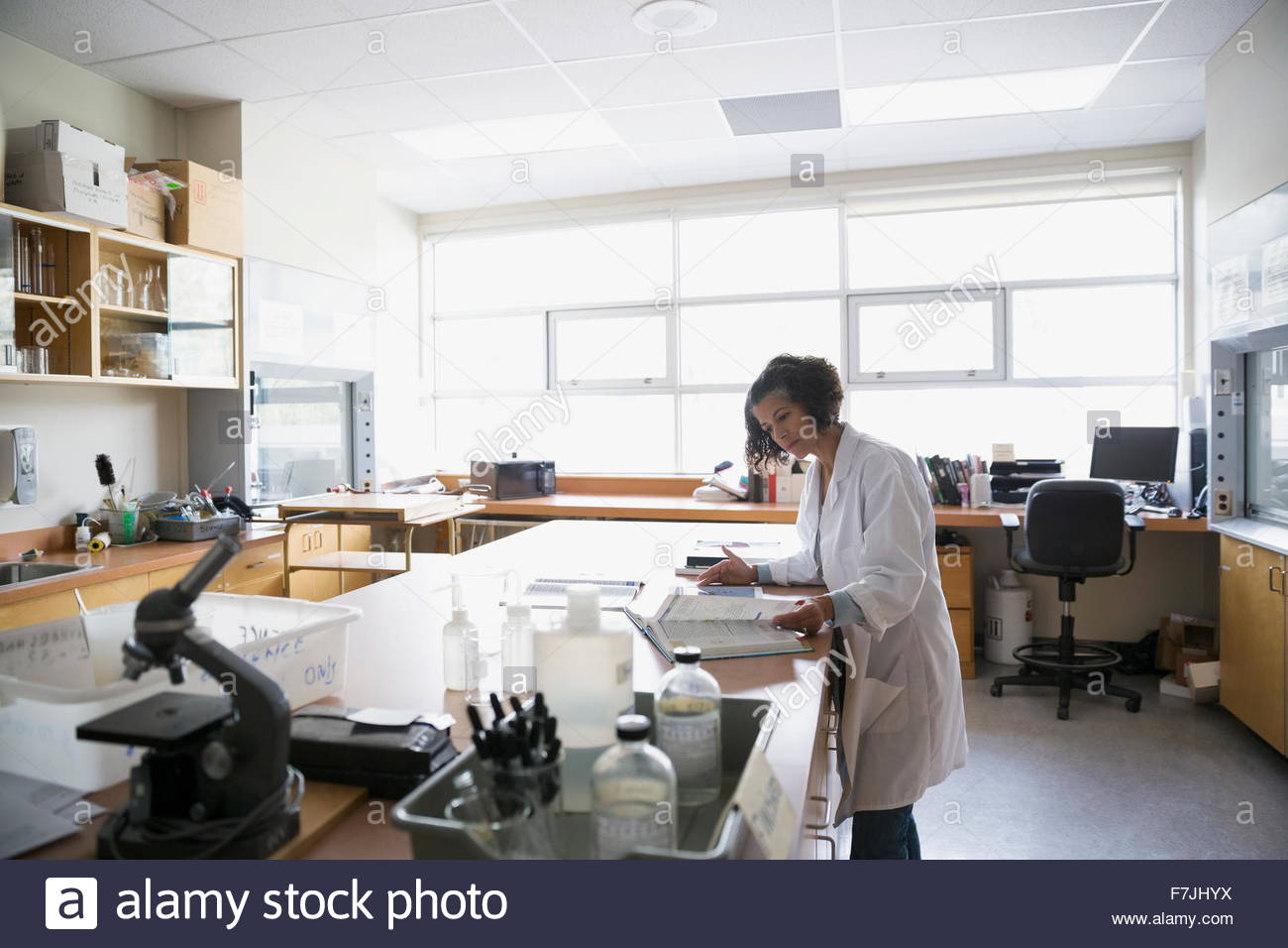 Profesor de ciencias prepara con libro de texto en clase de laboratorio Foto de stock