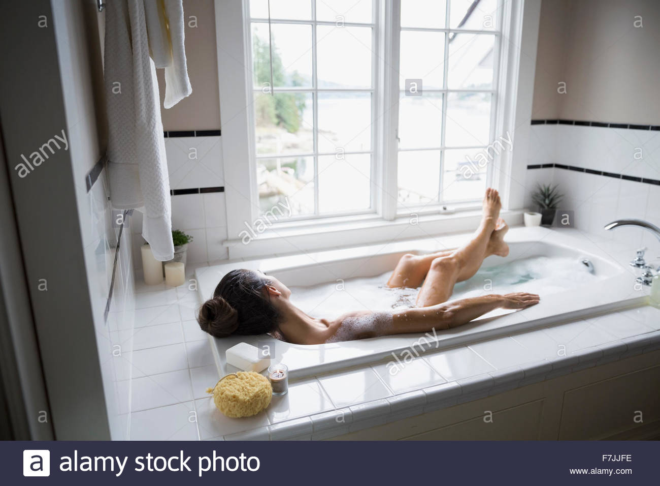 Mujer serena disfrutando el baño de burbujas Foto de stock