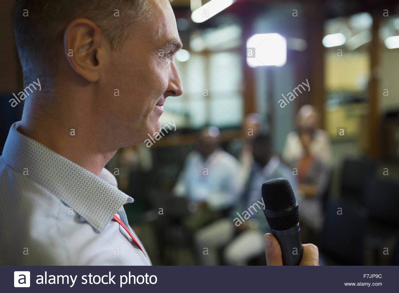 Cerrar el empresario con micrófono hablando en conferencias Foto de stock