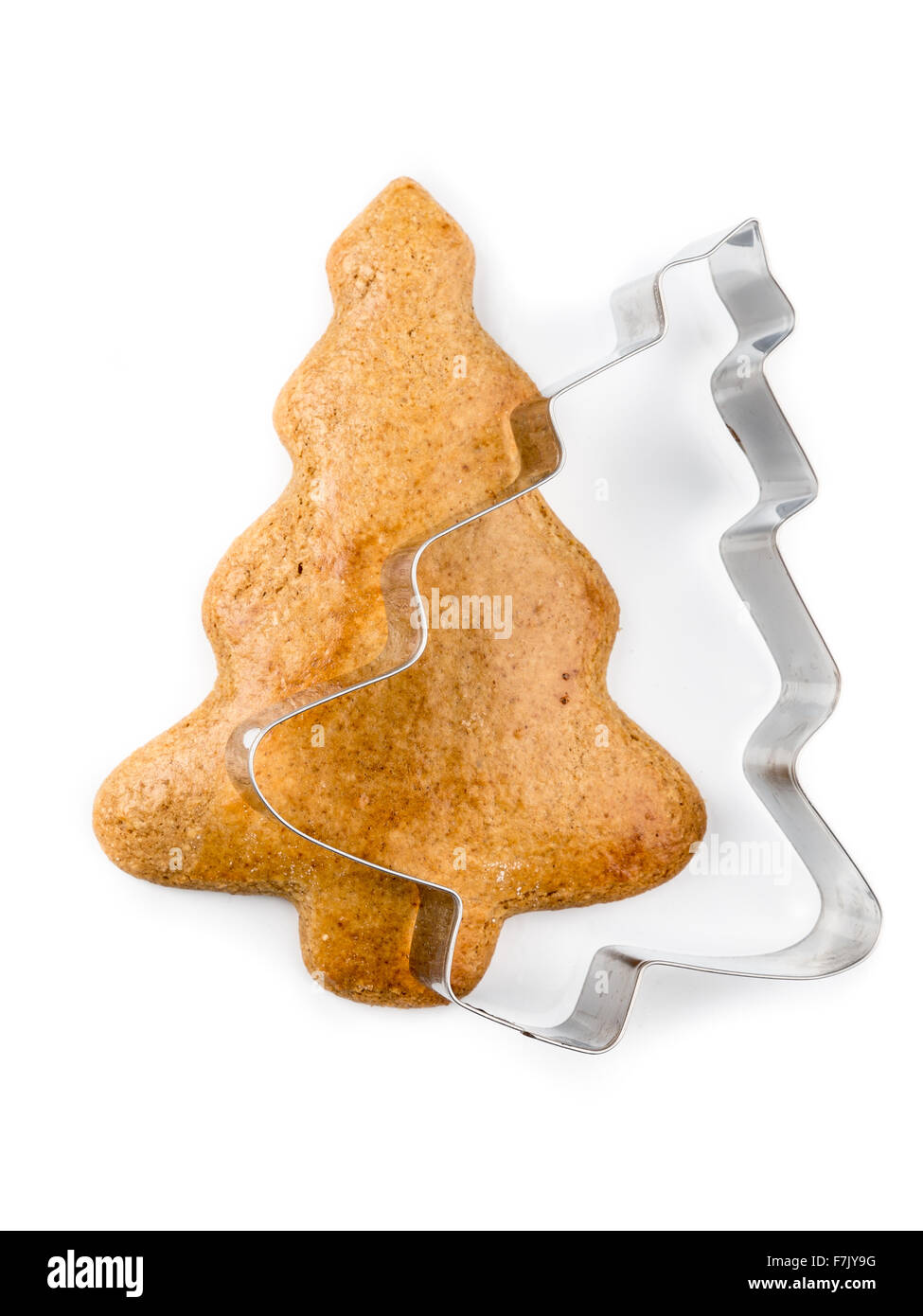 Árbol de Navidad-como gingerbread cookie con metal cookie cutter sobre fondo blanco. Foto de stock
