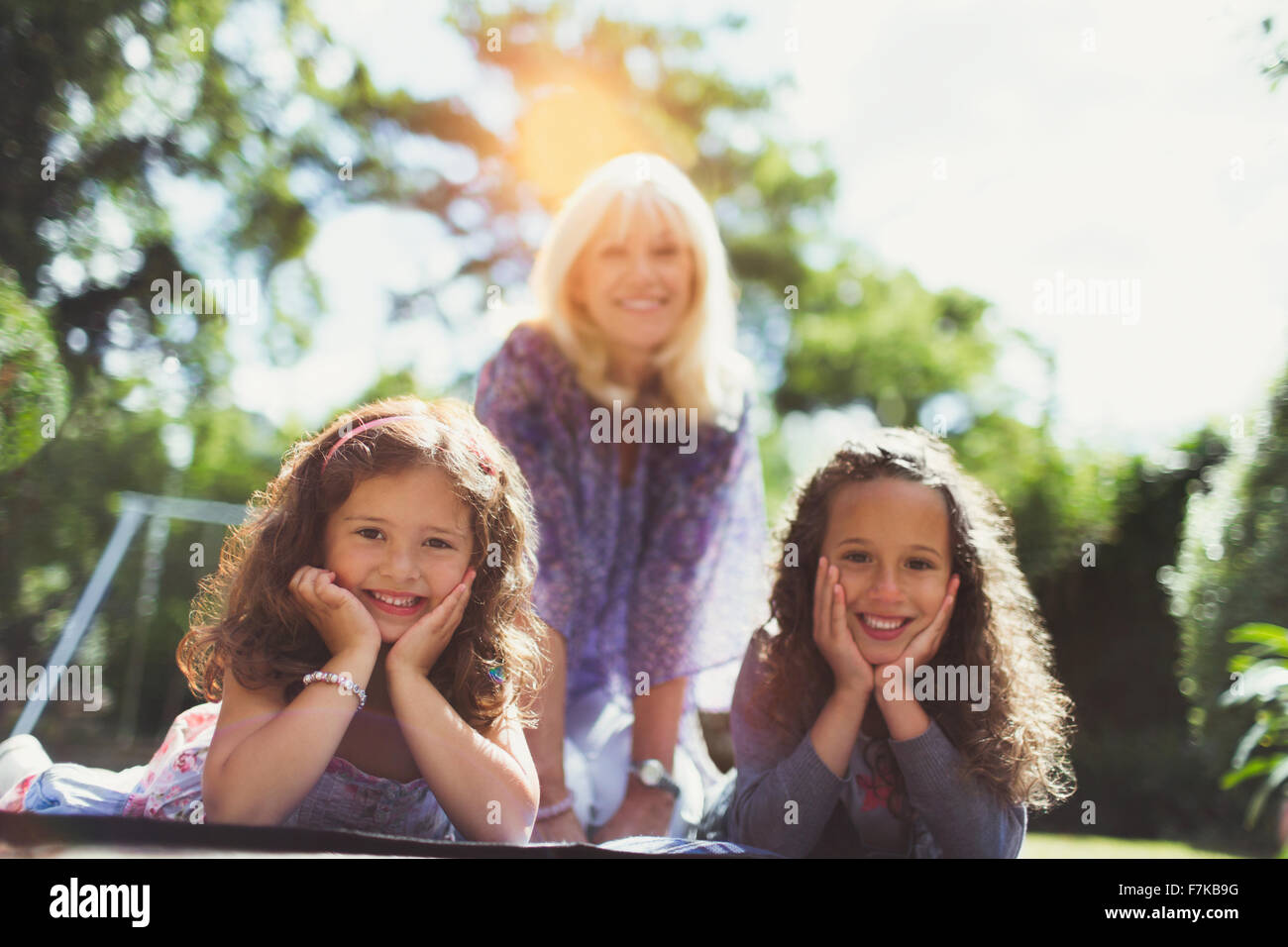 Retrato abuela sonriendo con dos nietas en estacionamiento Foto de stock