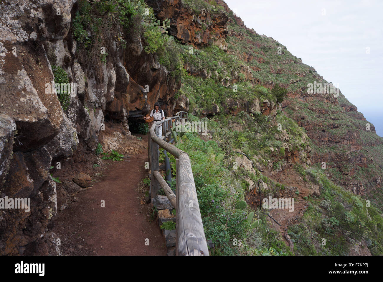 Caminante en camino a través de la pared roja encima de Agulo, isla de La Gomera, Islas Canarias, España Foto de stock