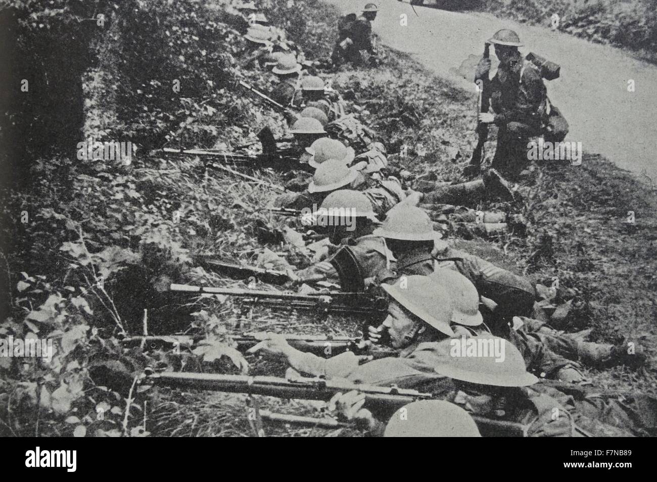 Fotografía de soldados tomando posición hacia arriba por la carretera. Fechado en 1940 Foto de stock