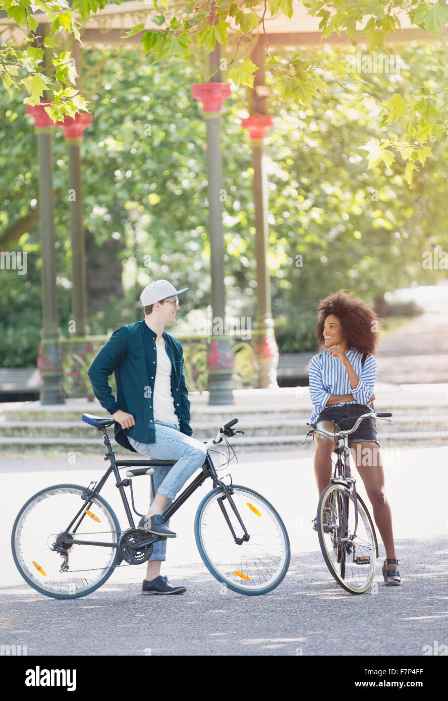 Amigos hablando sobre bicicletas en parque urbano Foto de stock