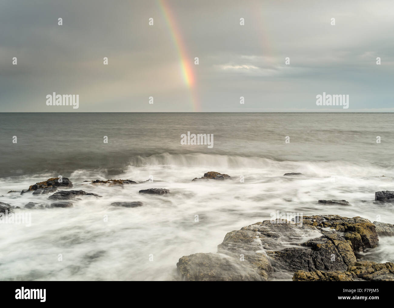 Arco iris sobre el Mar del Norte visto desde Craster, Northumberland, Inglaterra Foto de stock