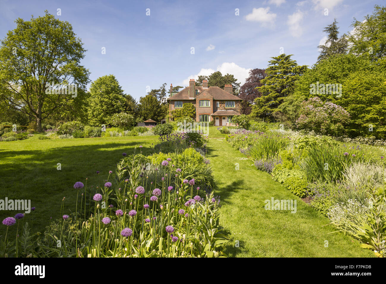 El jardín trasero bordes florales y vista lejana de la casa de Shaw's Corner, Hertfordshire Foto de stock
