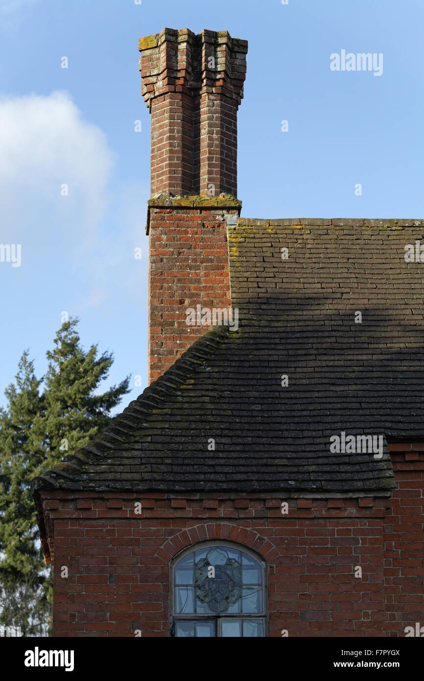 Detalle del techo y chimeneas en el jardín de la gama (lado sur) de pared de la casa de Baddesley Clinton, Warwickshire. Originalmente, el entramado de madera del rango se enfrentaba en ladrillo en la primera mitad del siglo XVIII, para ponerlo al día con el decimoctavo-centu Foto de stock
