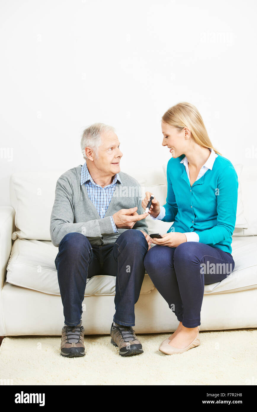 Mujer joven haciendo monitoreo de glucosa en la sangre para altos hombre en  casa Fotografía de stock - Alamy