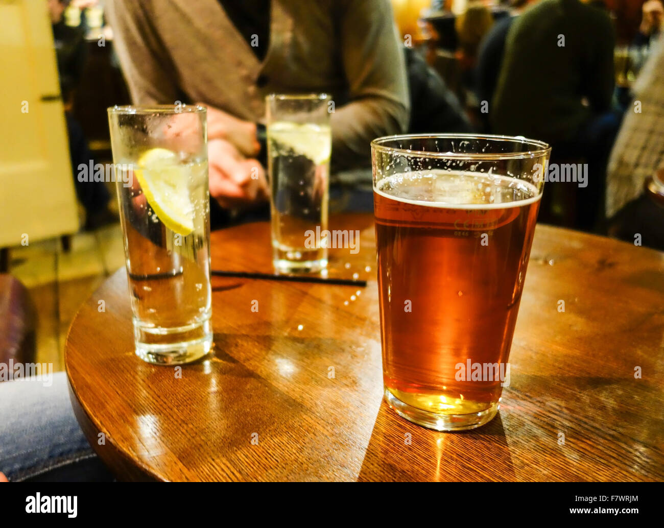 Una pinta de cerveza y 2 refrescos en un pub tabla Fotografía de stock