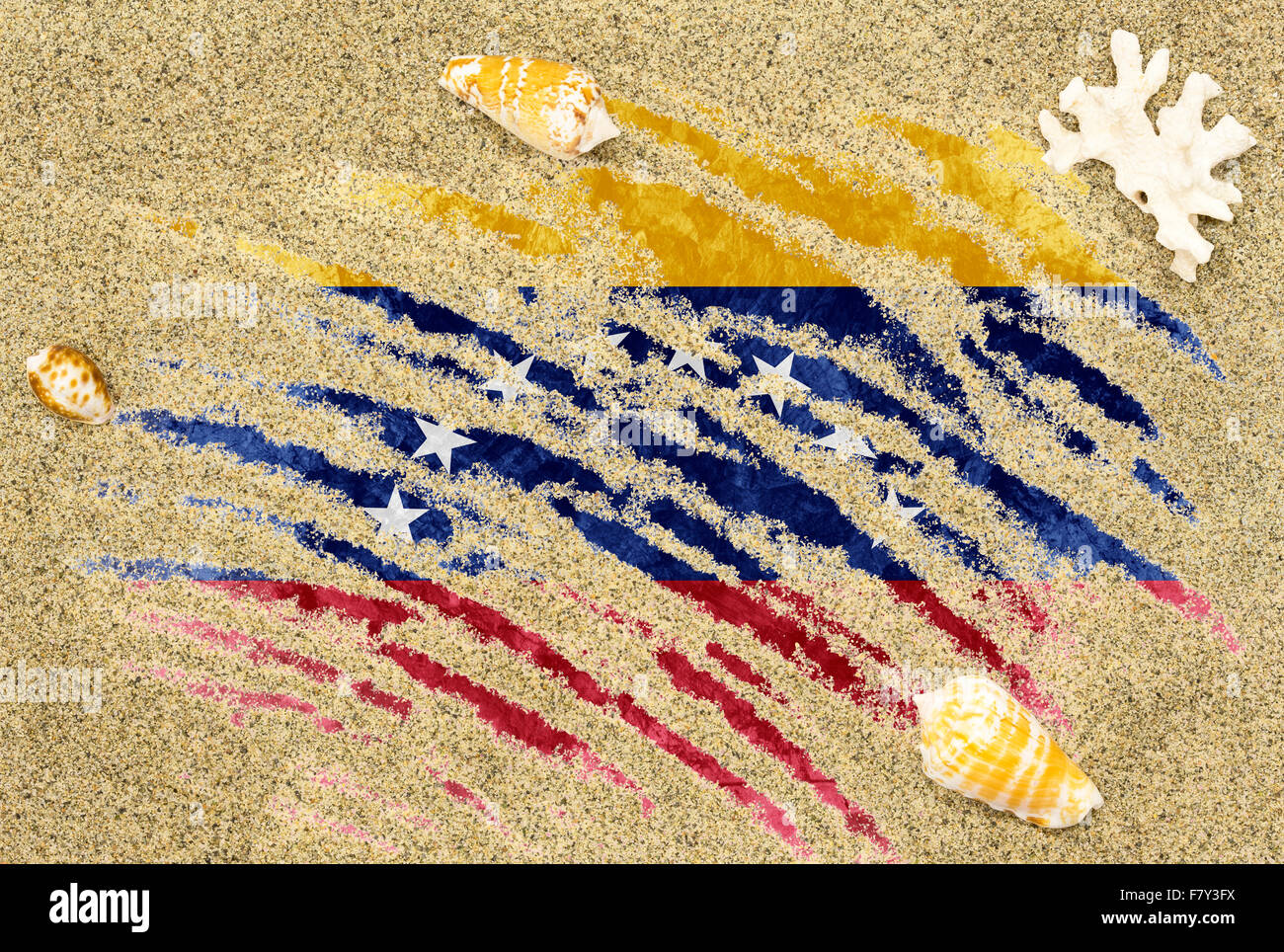 La bandera nacional de Venezuela bajo un fondo de playa con arena, conchas marinas y arrecifes Foto de stock