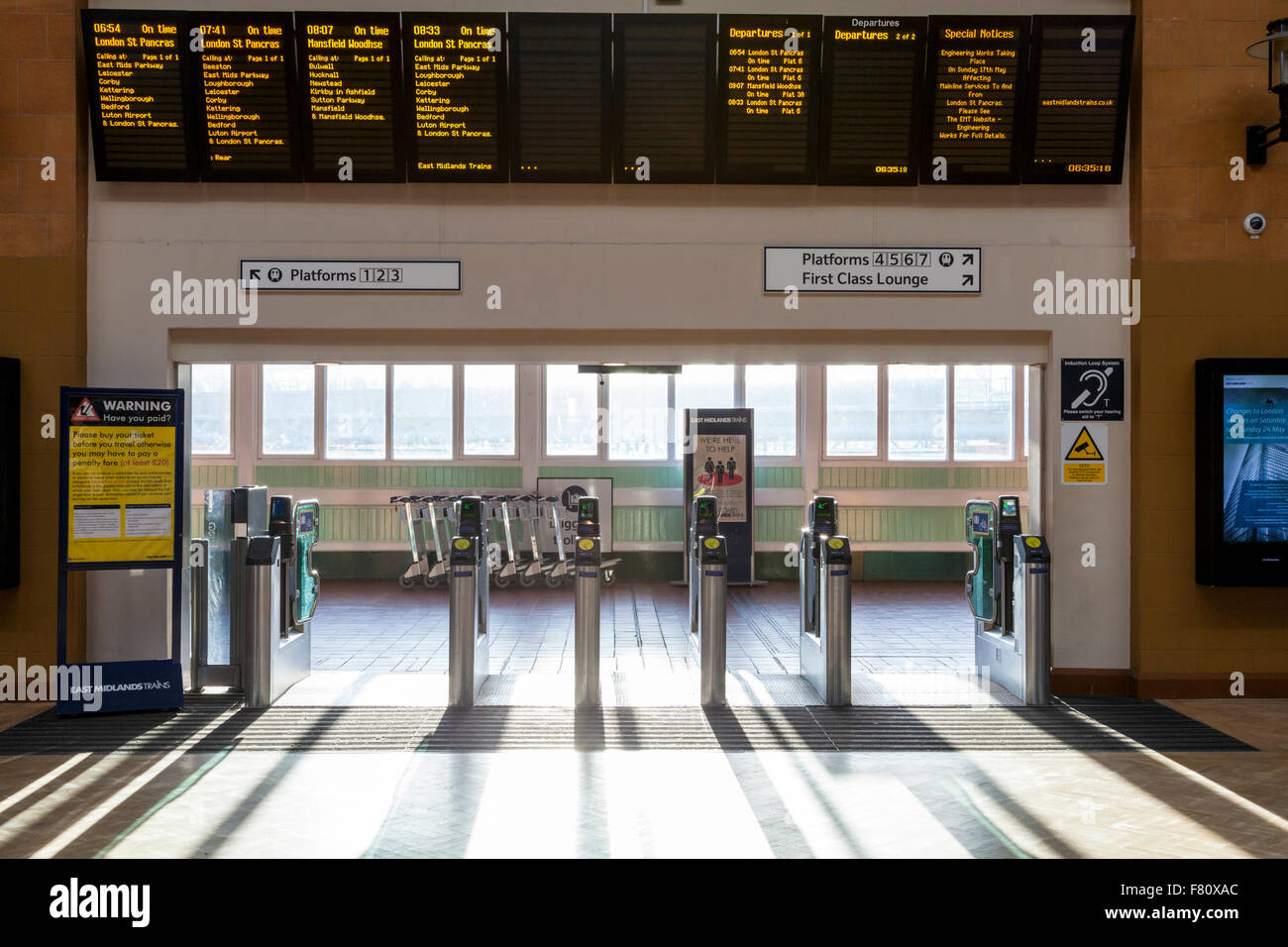 Entrada a la estación de trenes a través de barreras con billete de tren horarios de salida por encima de la junta, la estación de tren de Nottingham, Inglaterra, Reino Unido. Foto de stock