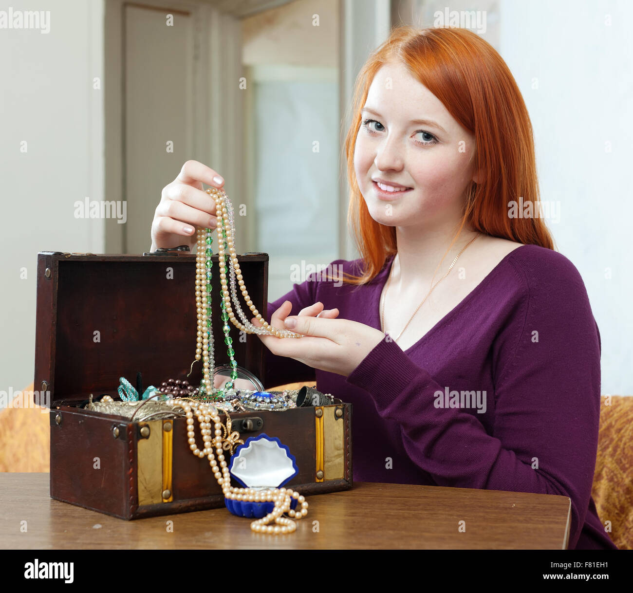 Joven busca joyas en el cofre del tesoro en casa Fotografía de stock - Alamy