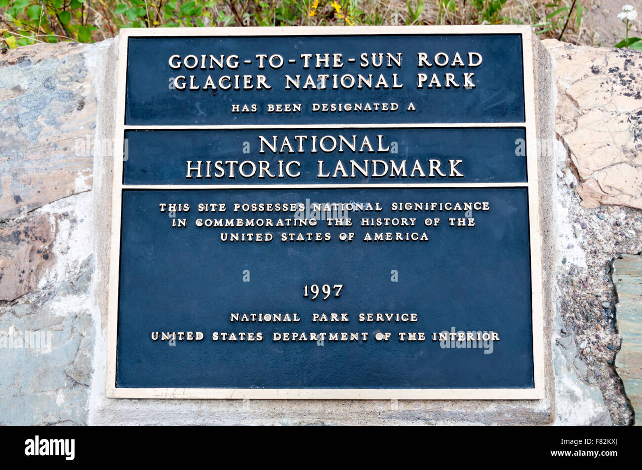 Una placa grabando la designación del Going-To-The-Sun Road en el Parque Nacional de Los Glaciares como un Hito Histórico Nacional. Foto de stock