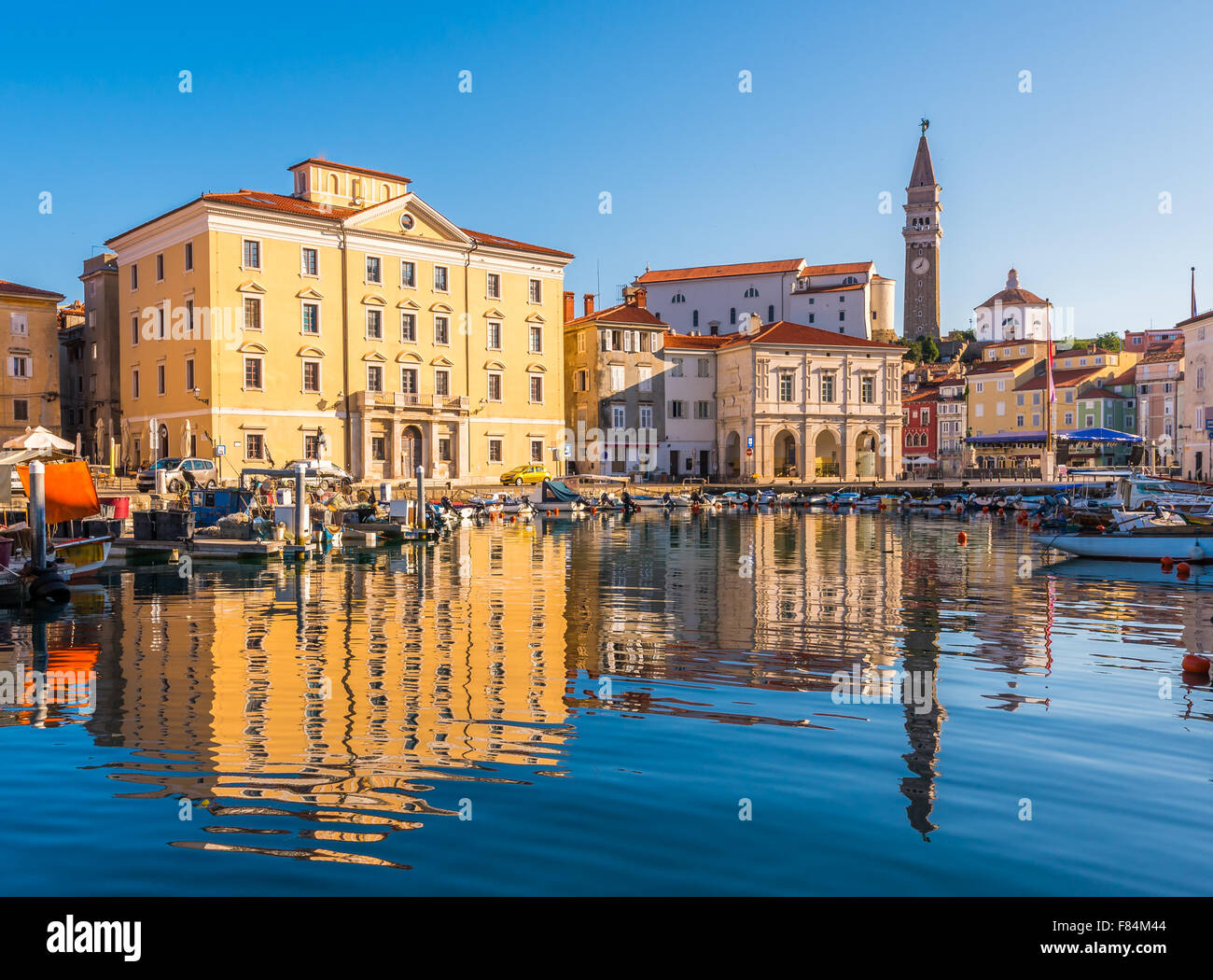 Puerto Veneciano y la plaza principal de Tartini Piran ciudad reflejada en el agua en Eslovenia. Foto de stock