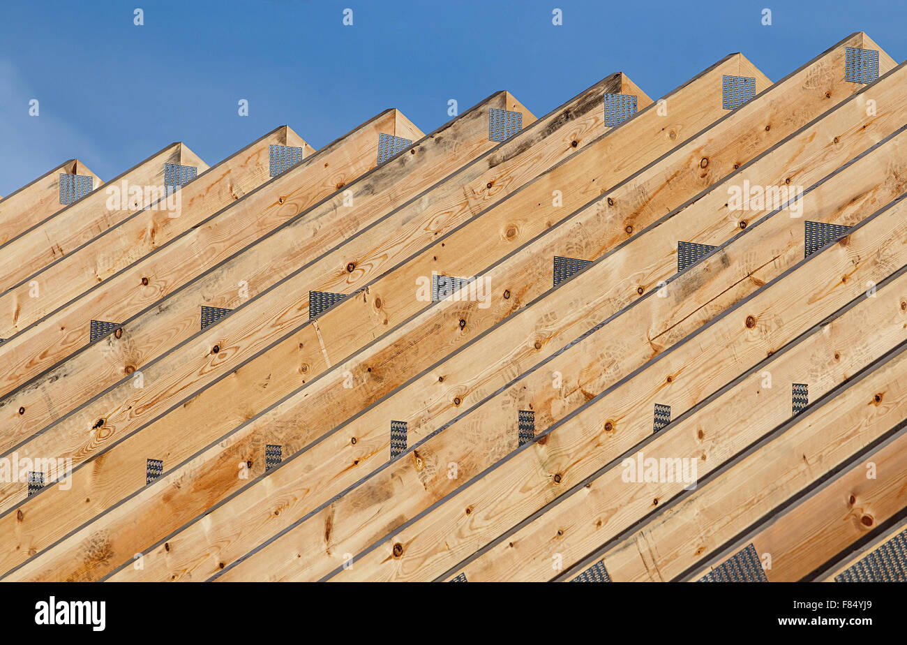 Fila de vigas de techo de madera en una línea en una moderna construcción del techo de un almacén de nueva construcción. Foto de stock