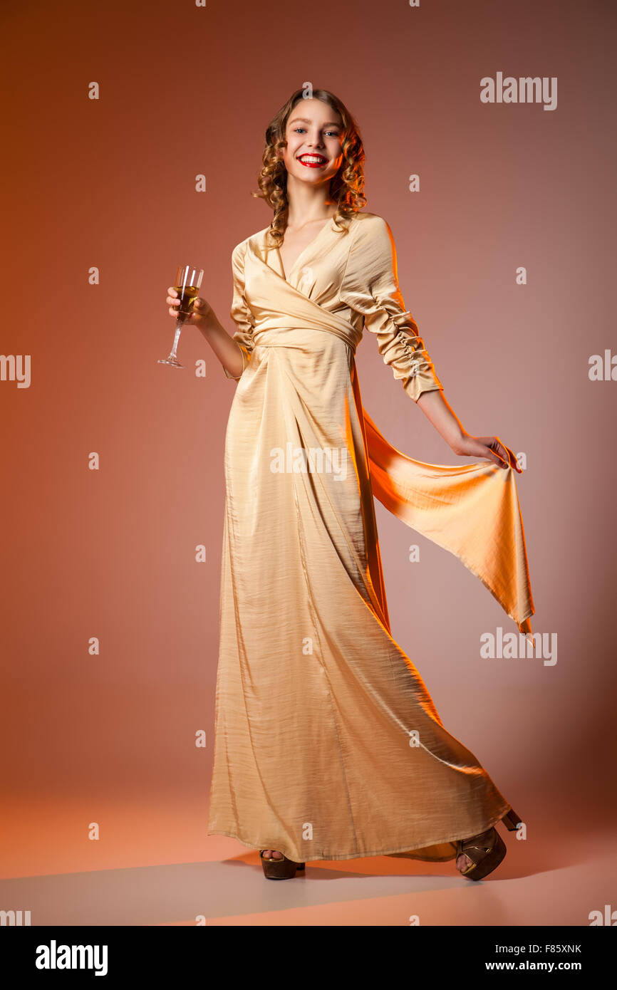 Mujer elegante vestido dorado con wineglass Fotografía de stock - Alamy