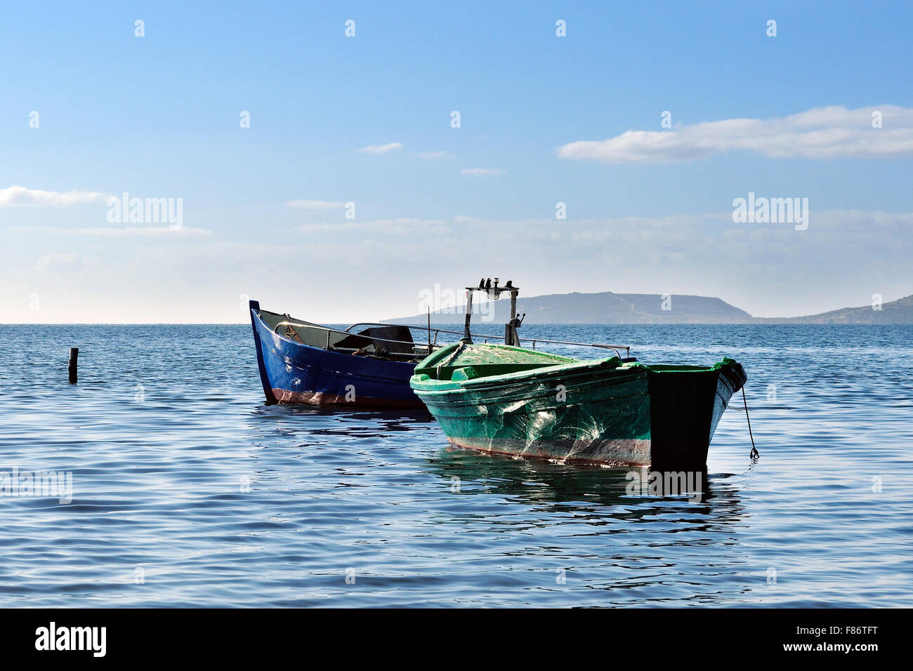 Barcos pesqueros amarrados en el tranquilo mar del golfo de Oristano Foto de stock