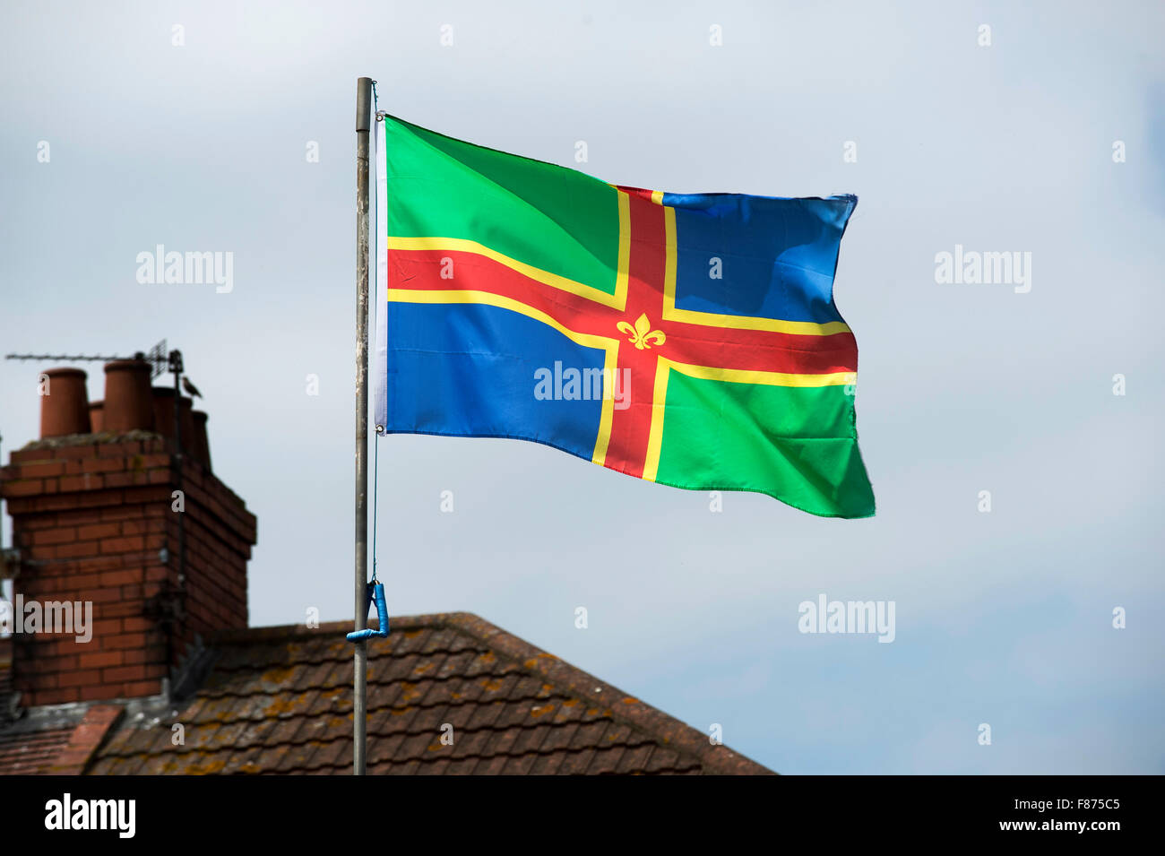 La bandera de Lincolnshire aleteo de un mástil sobre una casa en Grimsby, Lincolnshire. Foto de stock